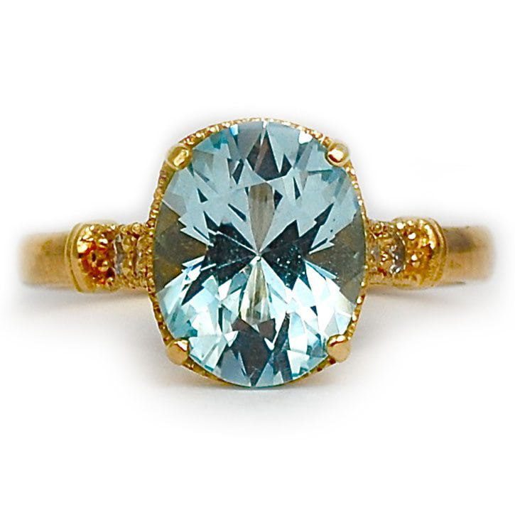 Custom engagement ring made with 14k yellow gold, 3 carat oval cut blue topaz, and diamond accents custom made and designed by Abby Sparks Jewelry, The JanMarie.