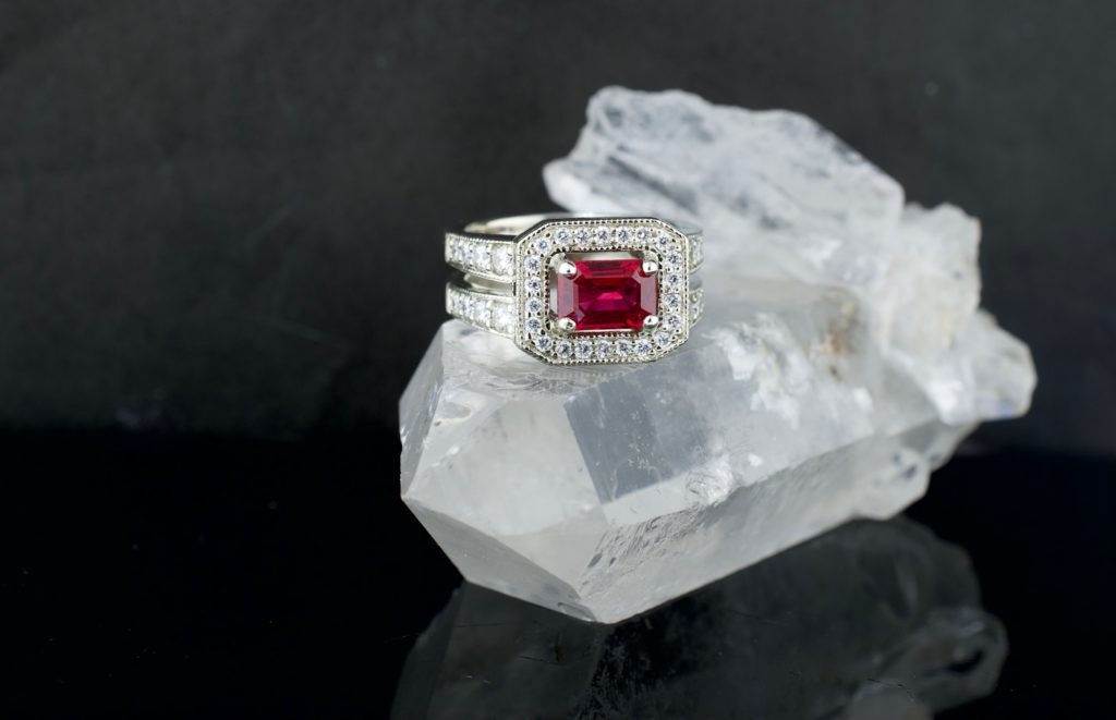 A custom ruby engagement ring in white gold ruby emerald cut floating-diamond halo double band named after Valerie and designed by Abby Sparks Jewelry