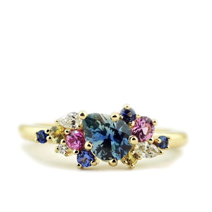 Handmade ring by Abby Sparks Jewelry with a pear cut Montana sapphire center stone and blue and pink sapphire clusters.